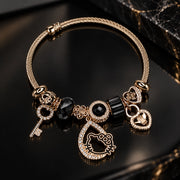 HB00068 - Gold Tone Bangle Charm Bracelet with Black Crystal Beads, Crescent Kitty & Key Pendant