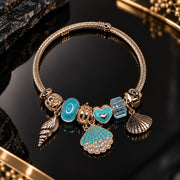 HB00074 - Gold Tone Ocean Bangle Charm Bracelet with Turquoise Shell, Conch & Heart Charms